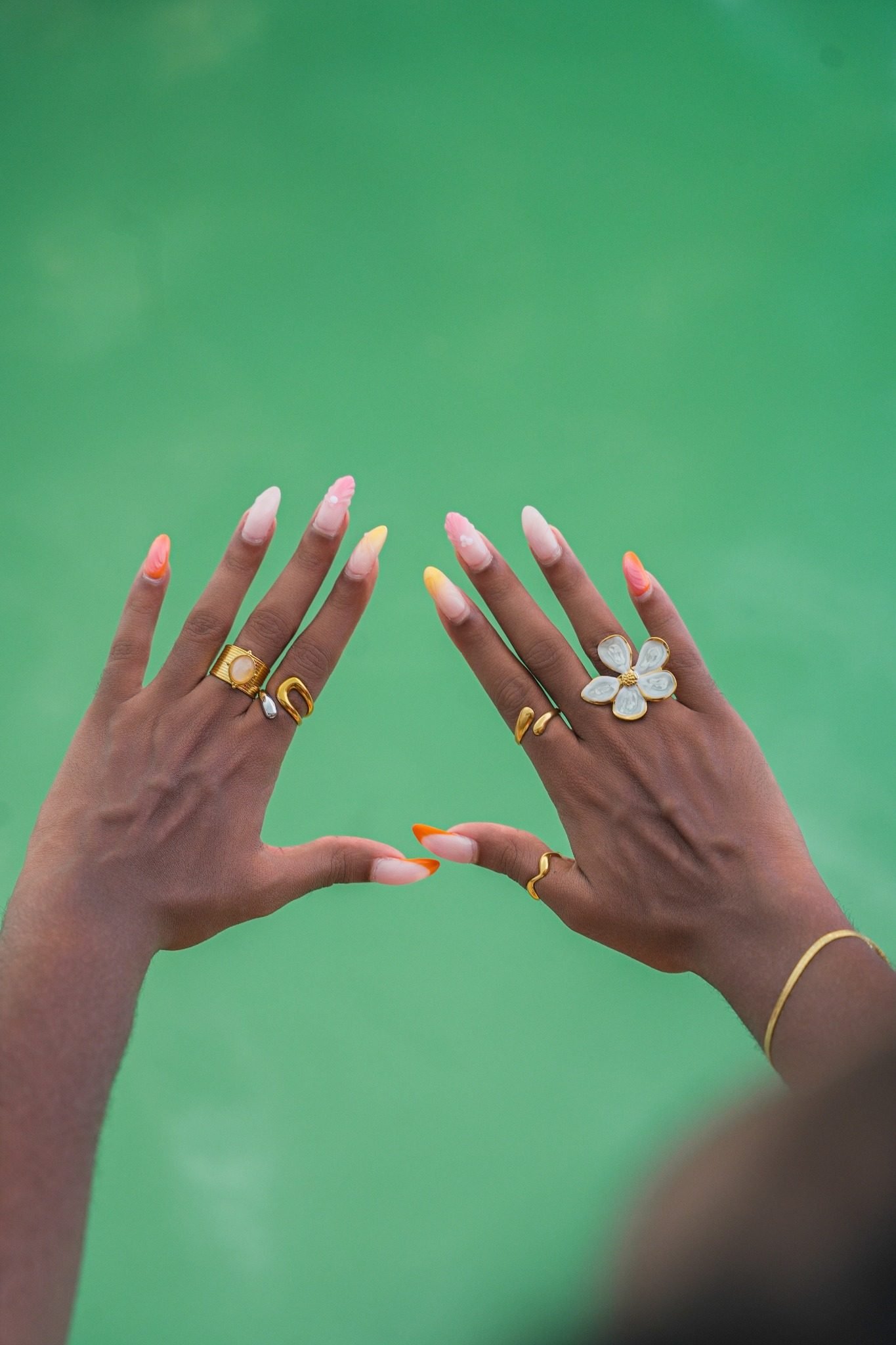 Deux mains baguées au-dessus de l’eau verte d’une piscine