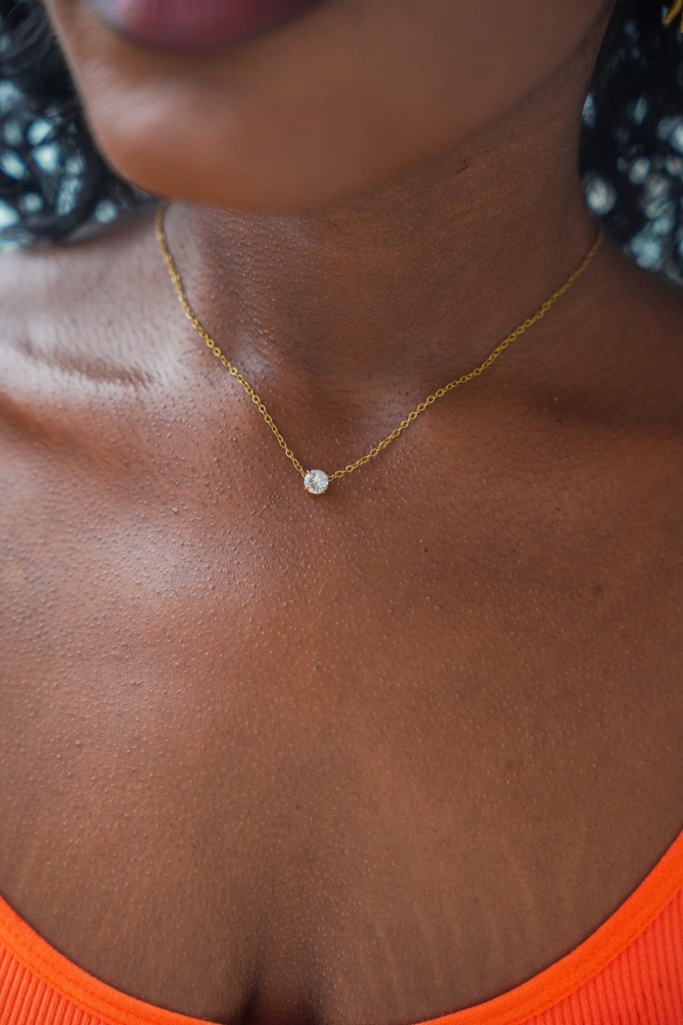 Collier solitaire doré sur la peau
