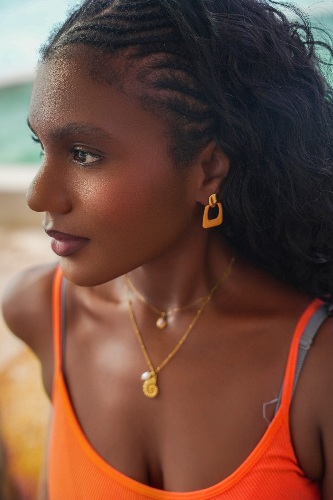 Portrait au bord de l’océan, colliers dorés superposés et boucles d’oreilles BAOBA